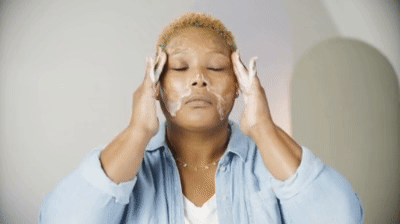 mid-shot of woman washing face around her lash extensions