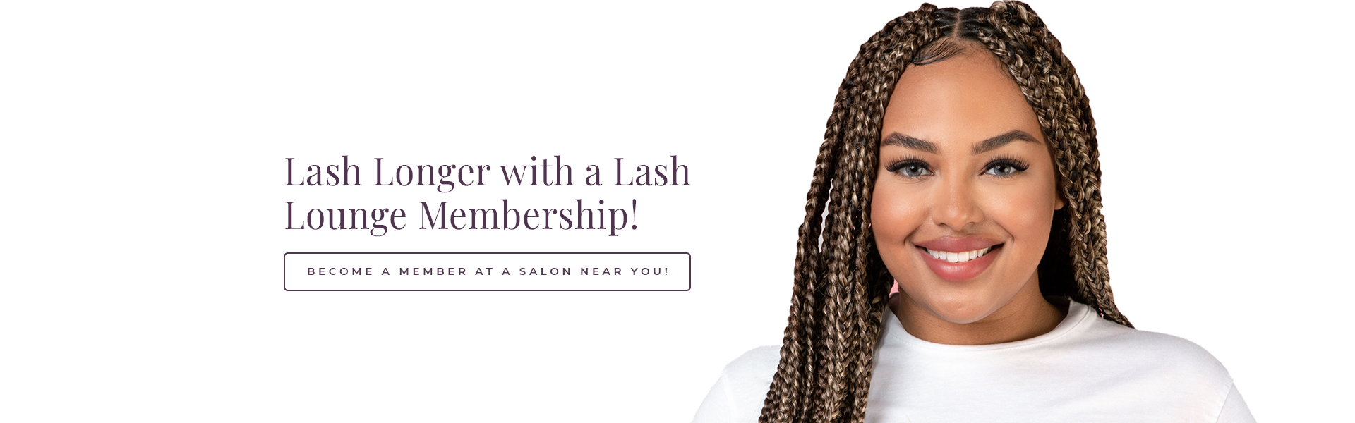 Black woman in a white tshirt smiling in front of a grey background.