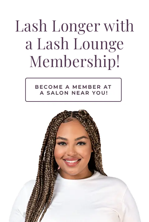 Black woman in a white tshirt smiling in front of a grey background.